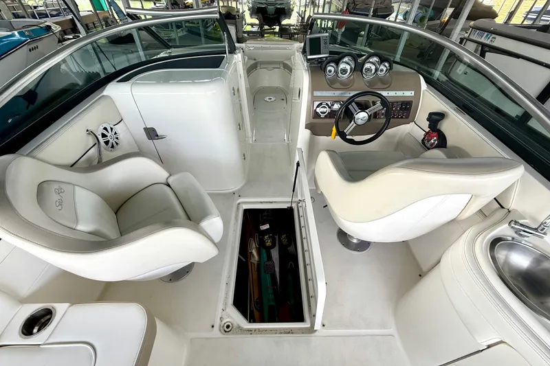 Slide: The Image of 2013 Sea Ray 260 Sundeck interior with helm, seating, and storage compartment. - 23