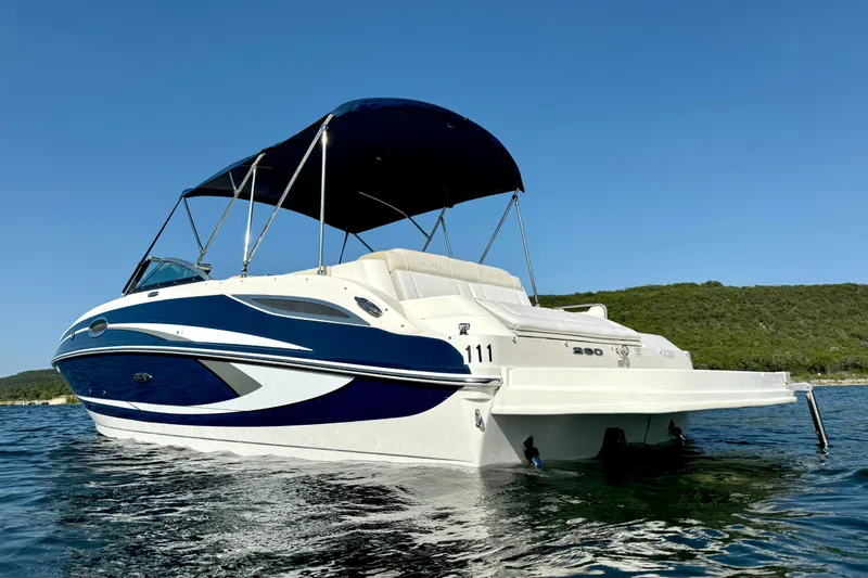Slide: The Image of 2013 Sea Ray 260 Sundeck boat on water, featuring sleek design and canopy. - 5