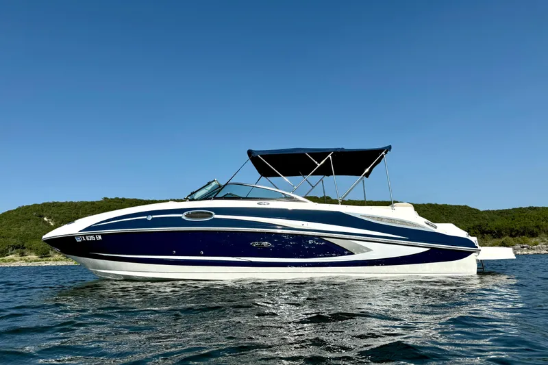 Slide: The Image of 2013 Sea Ray 260 Sundeck boat on calm water under clear blue sky. - 6