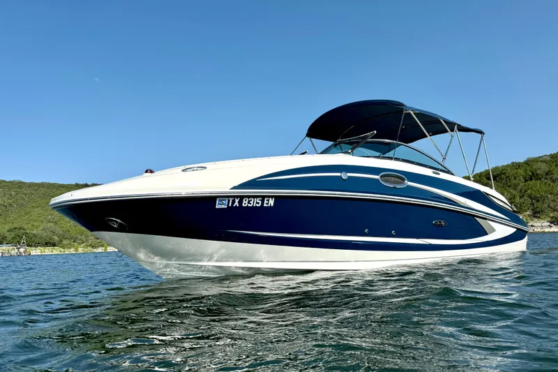 Slide: The Image of 2013 Sea Ray 260 Sundeck boat on water, blue and white design, sunny day. - 7