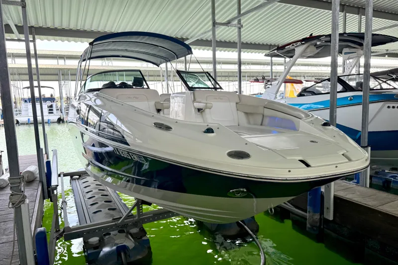 Slide: The Image of 2013 Sea Ray 260 Sundeck boat docked in a covered marina, showcasing sleek design. - 11