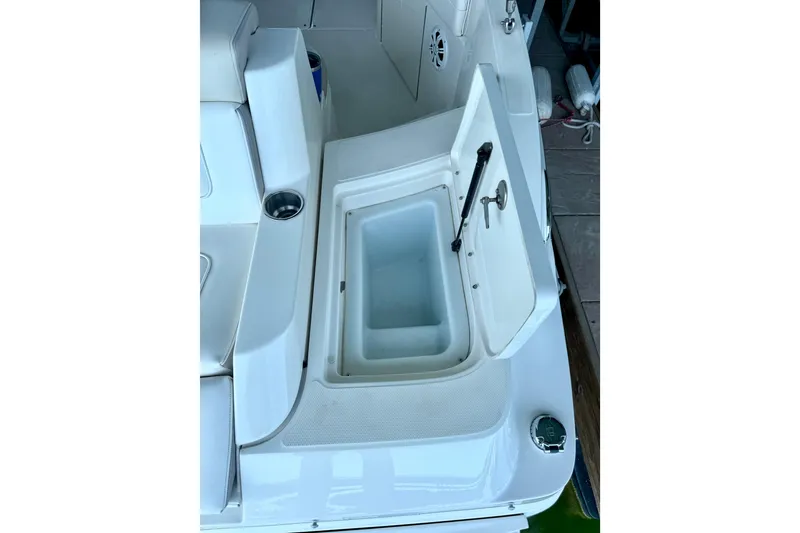 Slide: The Image of 2013 Sea Ray 260 Sundeck boat with open storage compartment and cup holder. - 26