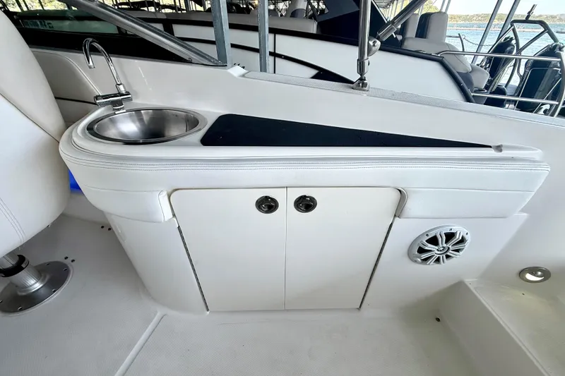 Slide: The Image of 2013 Sea Ray 260 Sundeck interior with sink, storage, and speaker. - 21