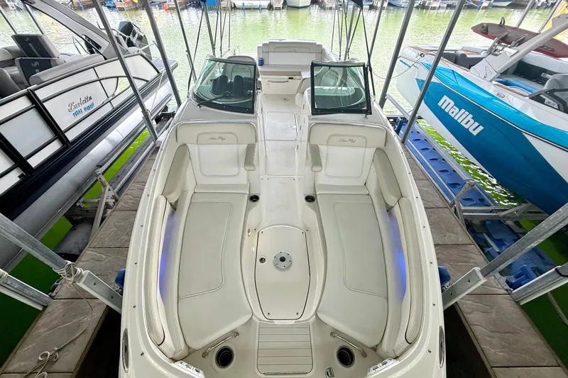 Slide: The Image of 2013 Sea Ray 260 Sundeck boat docked, showcasing spacious seating and sleek design. - 15