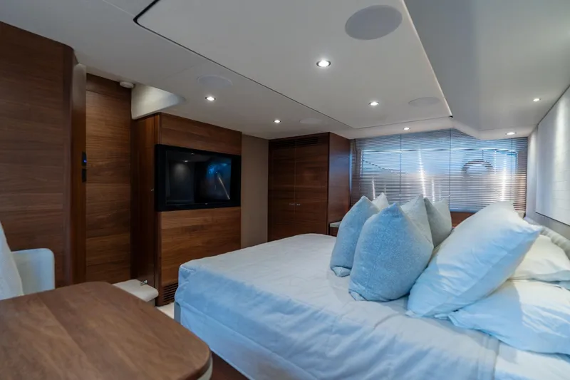 Slide: The Image of Luxurious 2021 Princess F55 yacht bedroom with modern wood paneling and ambient lighting. - 14
