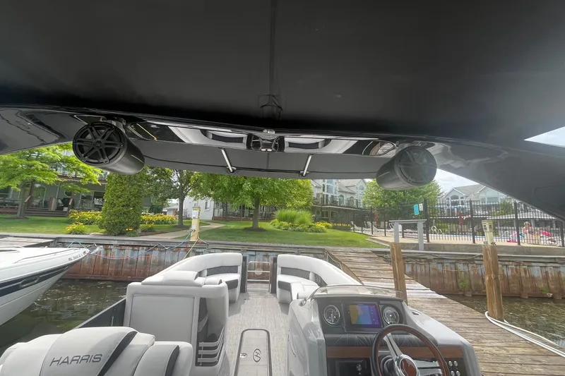 Slide: The Image of 2024 Harris Grand Mariner 250 boat interior with modern dashboard and waterfront view. - 13