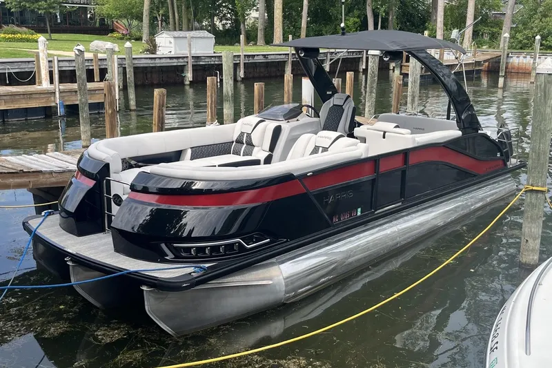 The Image of 2024 Harris Grand Mariner 250 pontoon boat docked in a marina. - 0