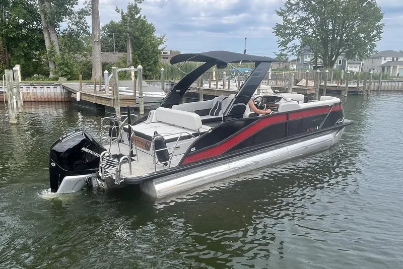 Slide: The Image of 2024 Harris Grand Mariner 250 pontoon boat on water, featuring sleek design and Mercury outboard engine. - 3