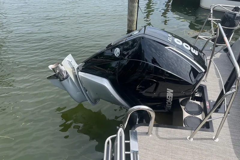 Slide: The Image of 2024 Harris Grand Mariner 250 with Mercury outboard engine docked on water. - 28