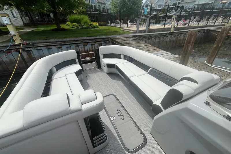 Slide: The Image of 2024 Harris Grand Mariner 250 pontoon boat with luxurious seating at a dock. - 14
