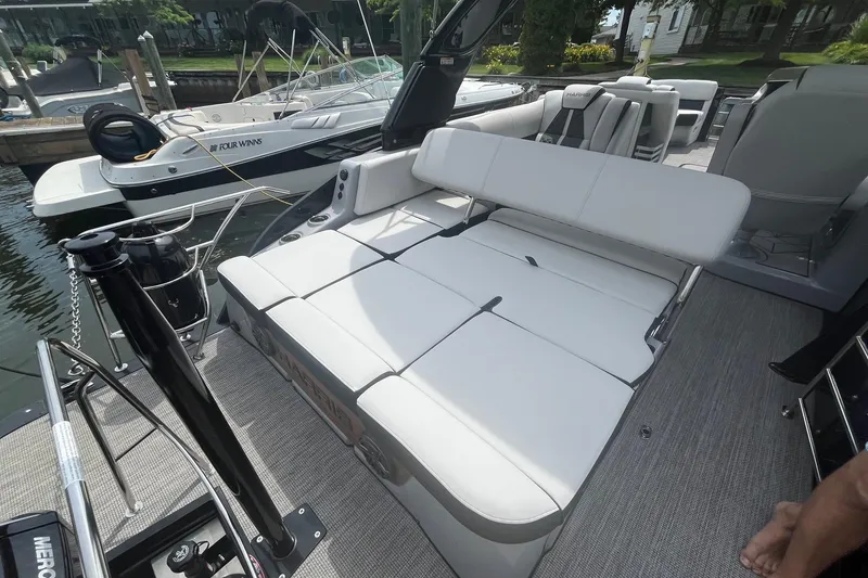 Slide: The Image of 2024 Harris Grand Mariner 250 boat with spacious seating and modern design at a dock. - 23