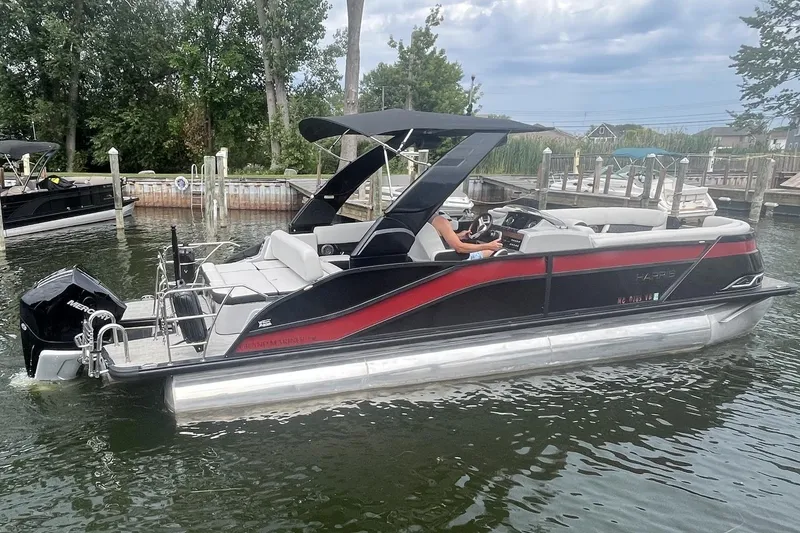 Slide: The Image of 2024 Harris Grand Mariner 250 pontoon boat on water, featuring sleek design and modern amenities. - 2