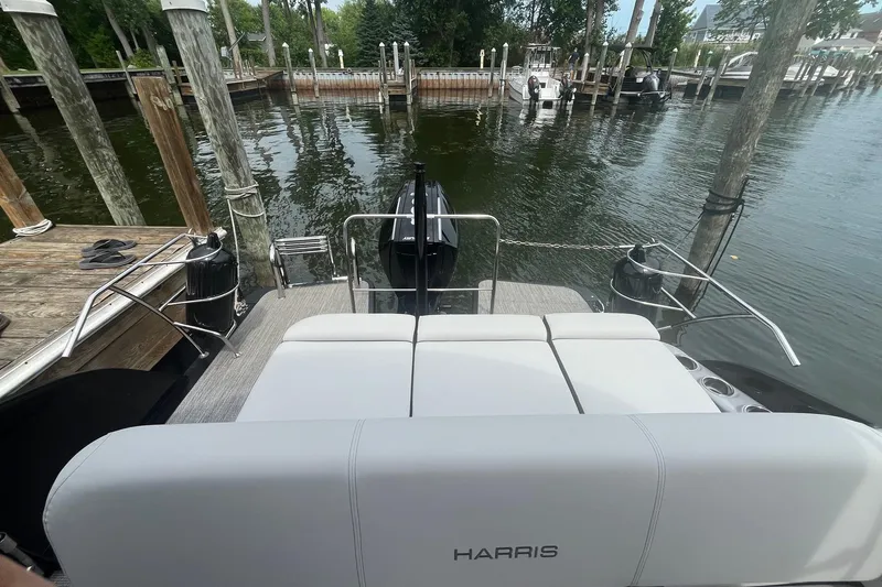 Slide: The Image of 2024 Harris Grand Mariner 250 pontoon boat docked at a serene marina. - 22