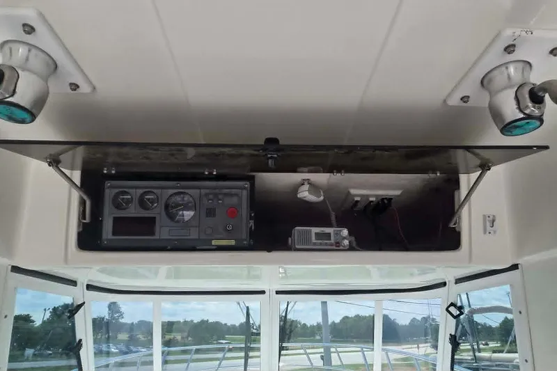 Slide: The Image of 2003 True World Marine 286 boat dashboard with gauges and electronics in open compartment. - 12