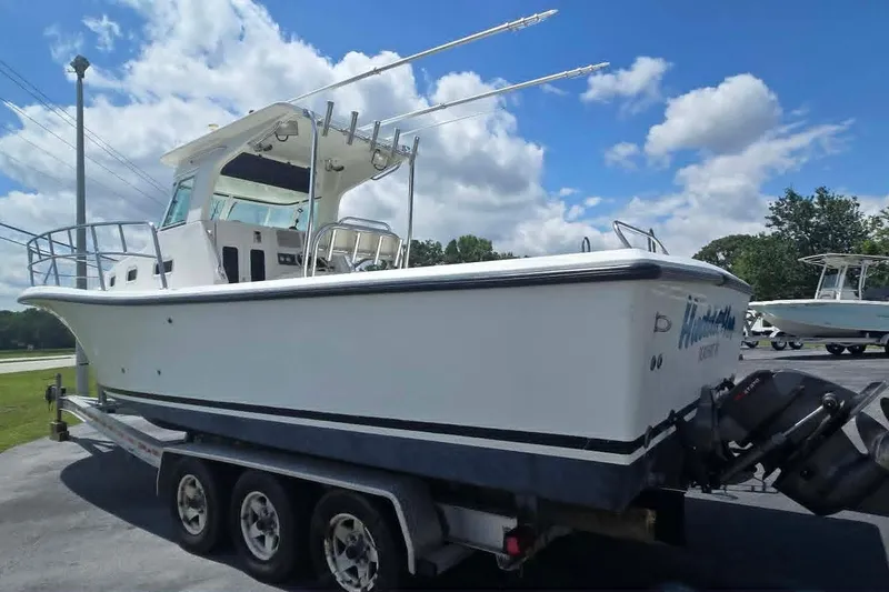 Slide: The Image of 2003 True World Marine 286 boat on trailer under a partly cloudy sky. - 4