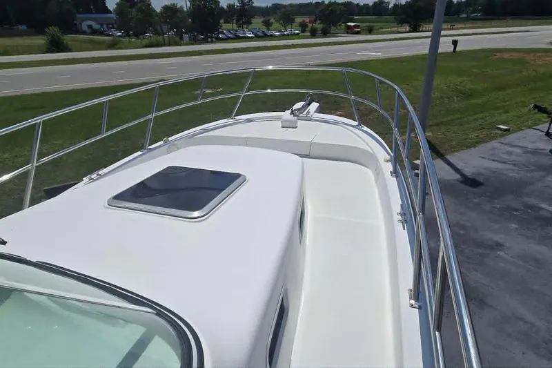 Slide: The Image of 2003 True World Marine 286 boat deck with railing and hatch, parked near a road. - 7
