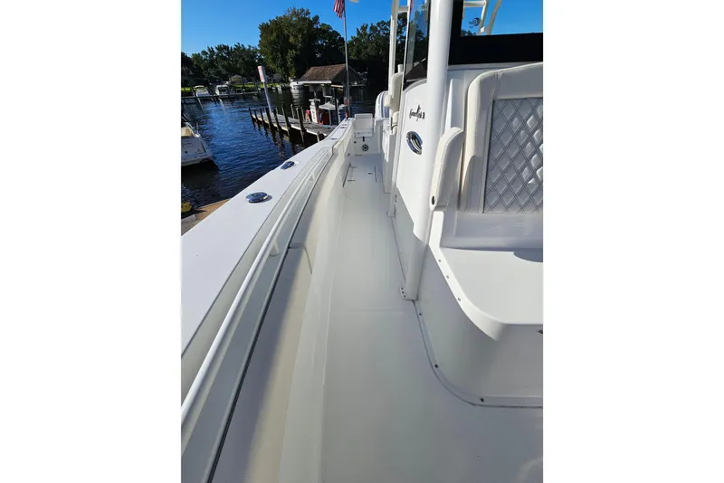 Slide: The Image of 2026 Sea Hunt Gamefish 30 Forward Seating boat docked by a serene waterfront. - 37