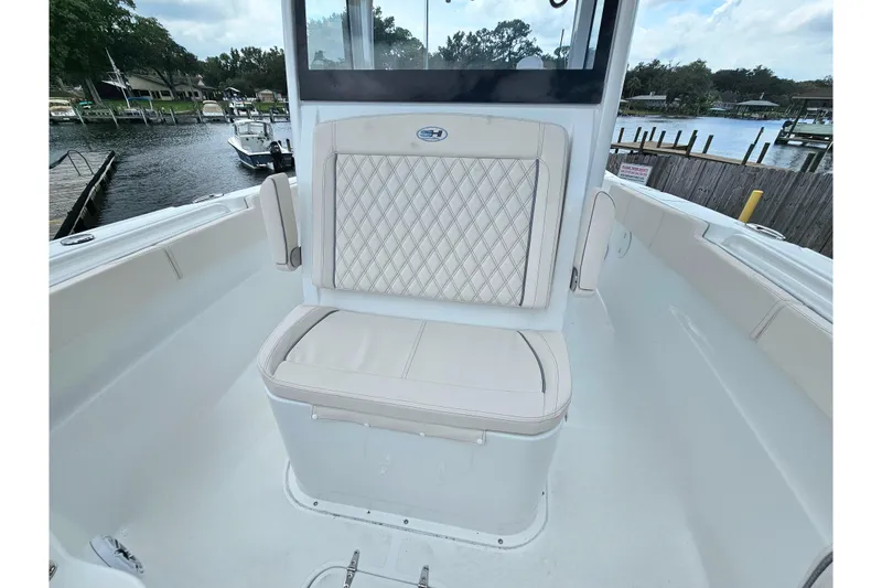 Slide: The Image of 2026 Sea Hunt Gamefish 30 Forward Seating with diamond-stitched upholstery, docked by a serene waterfront. - 35
