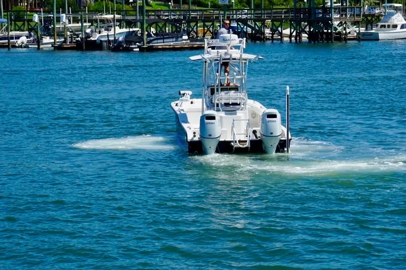 Slide: The Image of 2021 Tideline 235 boat cruising on blue water near a marina. - 3