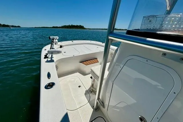 Slide: The Image of 2021 Tideline 235 boat on calm water, showcasing spacious deck and sleek design. - 8
