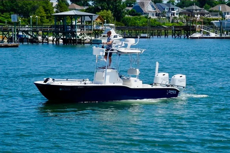 Slide: The Image of 2021 Tideline 235 boat cruising on a sunny day near a dock. - 2