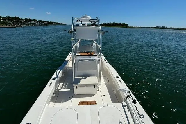 Slide: The Image of 2021 Tideline 235 boat on calm water, showcasing spacious deck and clear blue sky. - 9