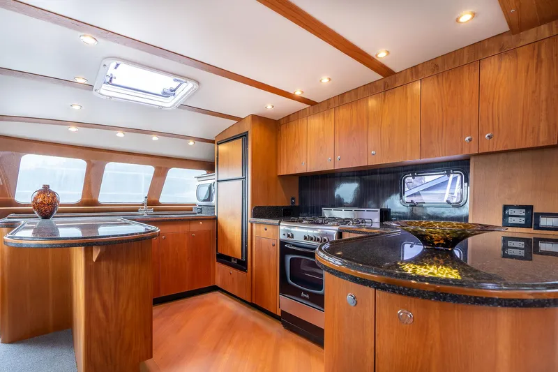 Slide: The Image of Luxurious kitchen interior of 2025 Shuttleworth 52 AeroRig yacht with wood cabinetry and modern appliances. - 26