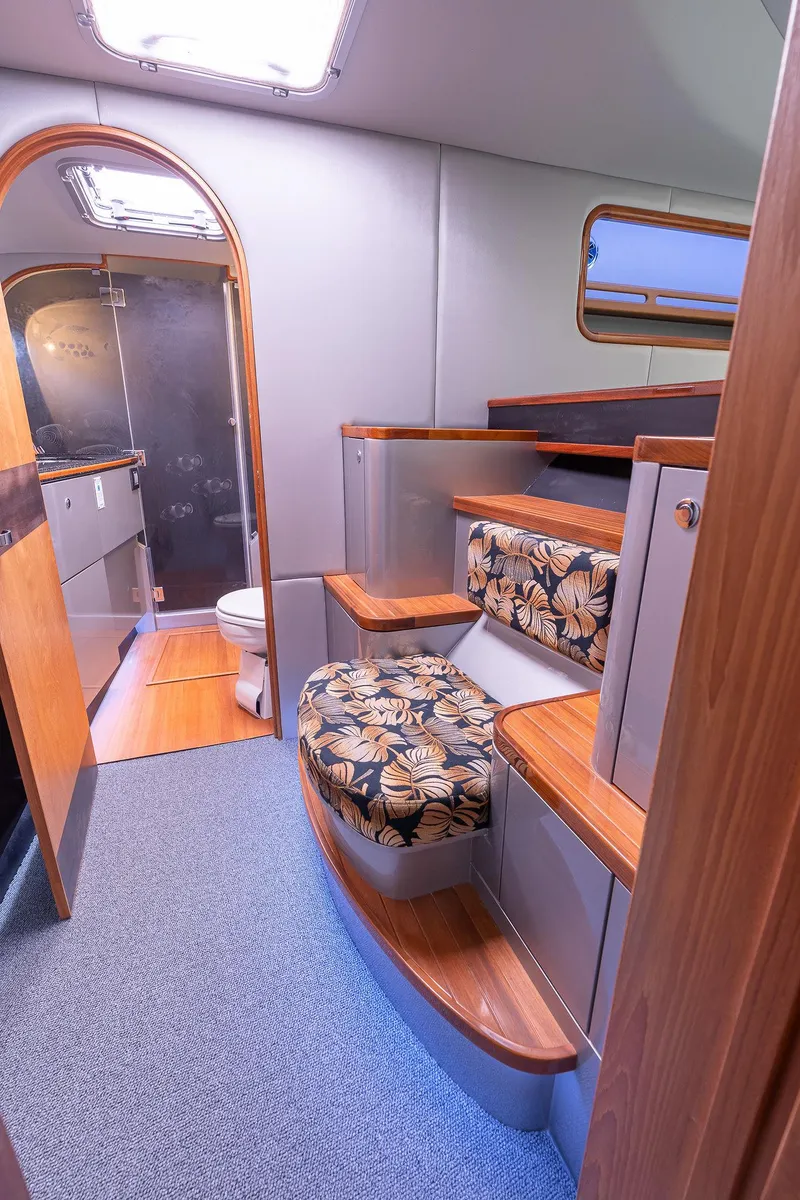 Slide: The Image of Interior of 2025 Shuttleworth 52 AeroRig yacht, featuring wooden steps and floral-patterned seating. - 43