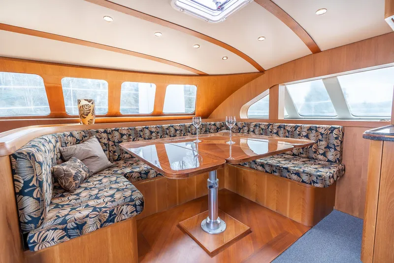 Slide: The Image of Luxurious interior of 2025 Shuttleworth 52 AeroRig yacht with elegant seating and wooden table. - 24