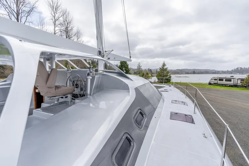 Slide: The Image of Modern 2025 Shuttleworth 52 AeroRig yacht docked by a scenic lakeside. - 9