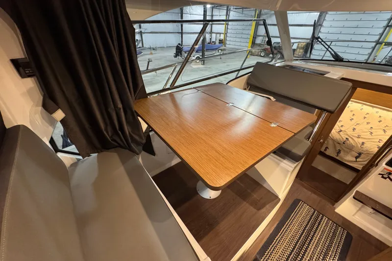 Slide: The Image of Interior of 2024 Beneteau Antares 9, featuring a wooden table and seating area. - 9
