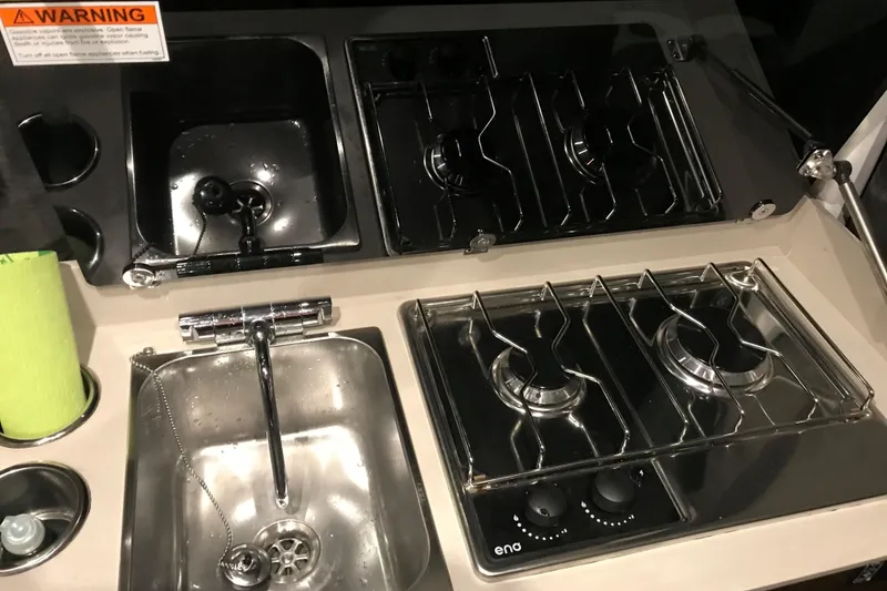 Slide: The Image of Compact kitchen area in 2024 Beneteau Antares 9 with stove and sink. - 4