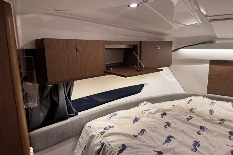 Slide: The Image of 2024 Beneteau Antares 9 cabin interior with wooden cabinets and seahorse-patterned bedding. - 19