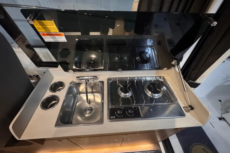 Slide: The Image of Compact kitchen area in 2024 Beneteau Antares 9 with stove and sink. - 13