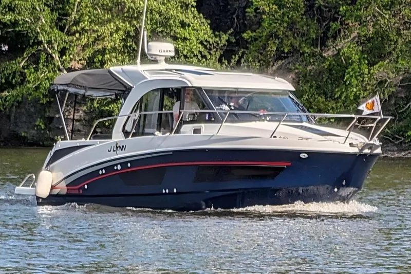 The Image of 2024 Beneteau Antares 9 cruising on a scenic river with lush greenery. - 0