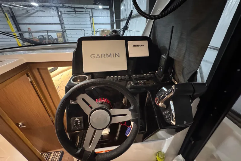 Slide: The Image of 2024 Beneteau Antares 9 helm with Garmin navigation and Mercury controls in a modern cockpit. - 14