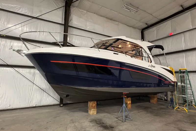 Slide: The Image of 2024 Beneteau Antares 9 boat in a warehouse, elevated on supports. - 23
