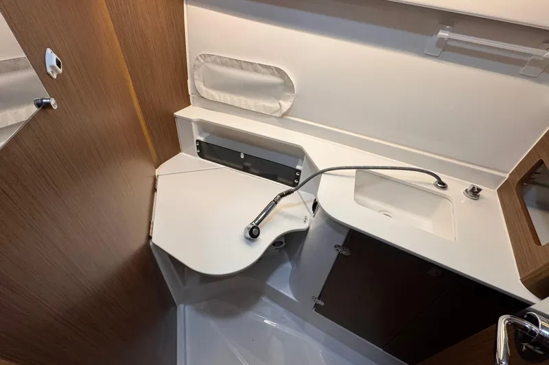 Slide: The Image of 2024 Beneteau Antares 9 bathroom with modern sink and wooden cabinetry. - 17
