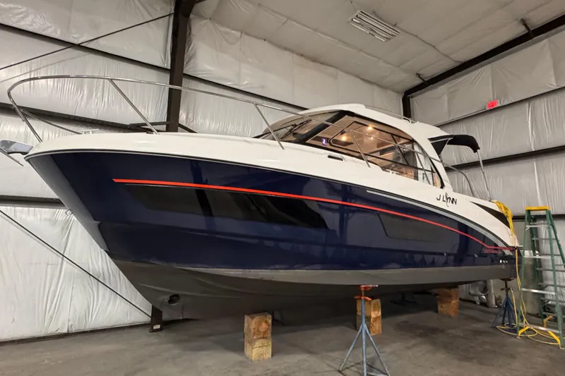Slide: The Image of 2024 Beneteau Antares 9 boat in a warehouse, elevated on blocks. - 1
