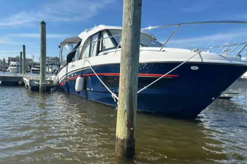 The Image of 2024 Beneteau Antares 9 docked at marina under clear blue sky. - 0