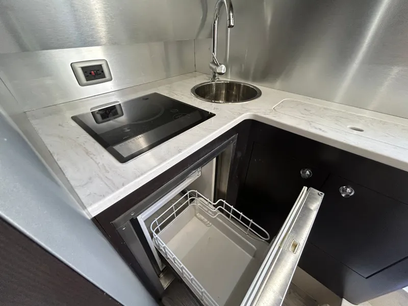 Slide: The Image of Compact kitchenette with sink, stove, and open dishwasher in a modern boat. - 17
