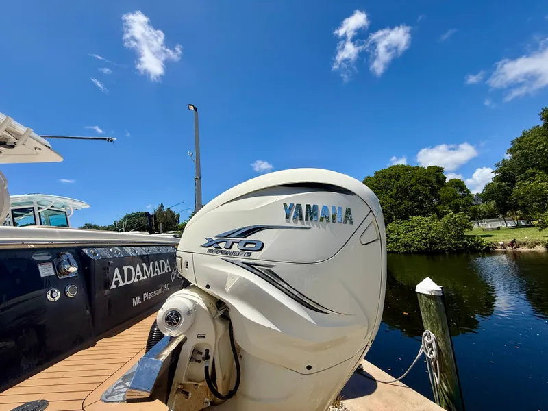 Slide: The Image of A 2021 Scout 380 boat with a Yamaha XTO outboard motor, docked by calm waters. - 11