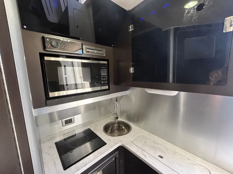 Slide: The Image of The galley of a 2021 Scout 380 with a microwave, sink, and stove. - 16