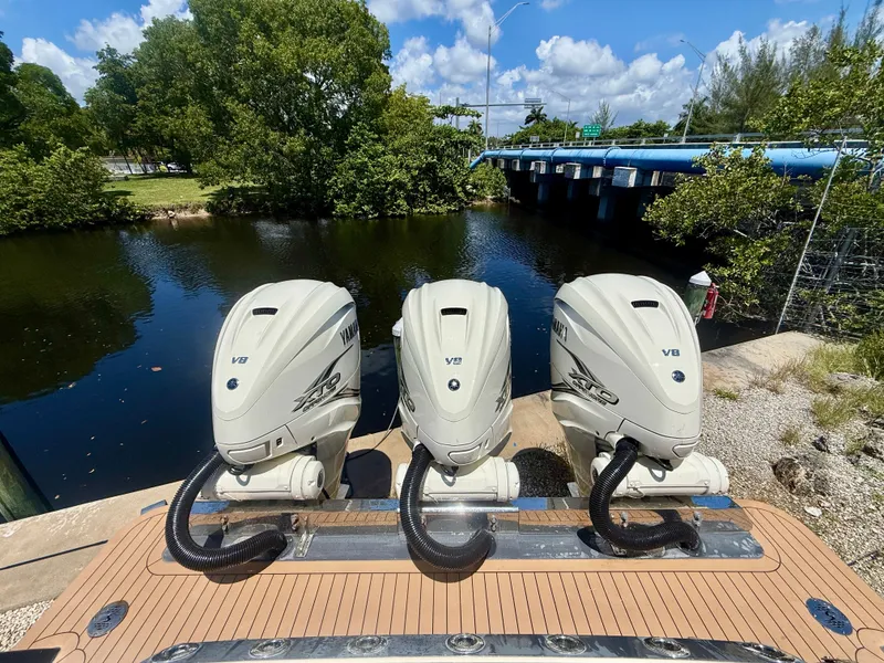 Slide: The Image of Three V8 outboard engines are mounted on the stern of a boat by a calm river. - 10