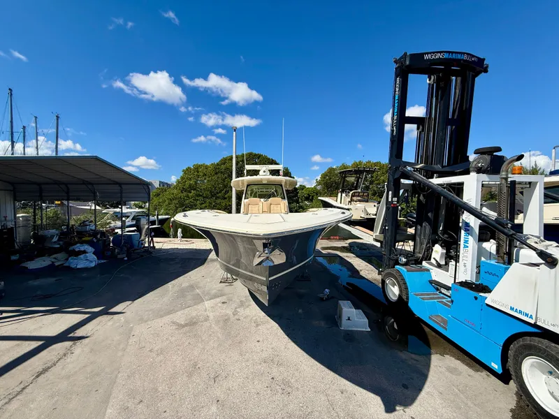 Slide: The Image of A 2021 Scout 380 boat is on a dry dock next to a forklift. - 23