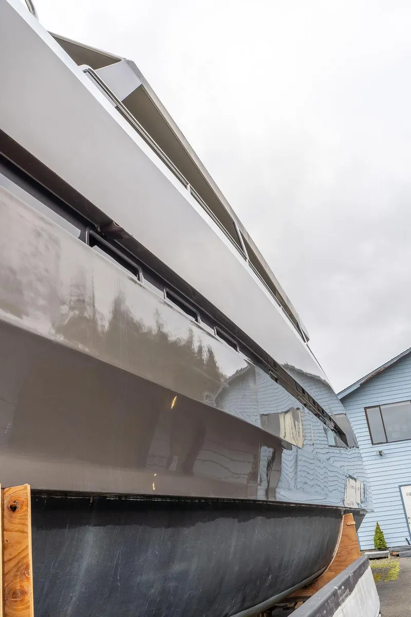 Slide: The Image of 2025 Catamaran Bloomfield 86 Motorsailor, sleek design, docked near a blue building. - 7