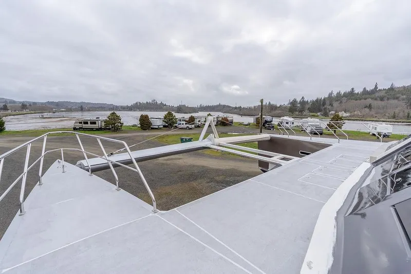 Slide: The Image of 2025 Catamaran Bloomfield 86 Motorsailor on land, showcasing deck and surrounding landscape. - 32