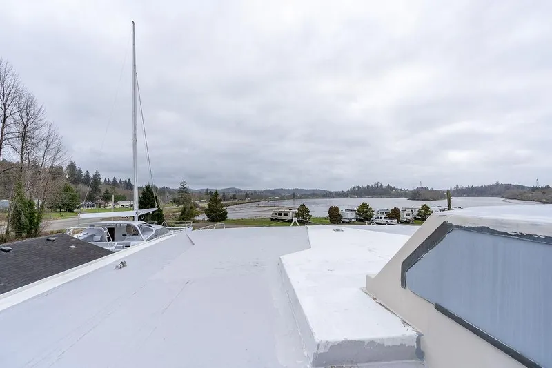 Slide: The Image of 2025 Catamaran Bloomfield 86 Motorsailor docked by a scenic lakeside view. - 19