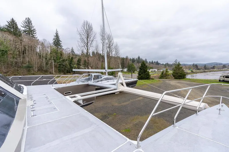 Slide: The Image of 2025 Catamaran Bloomfield 86 Motorsailor on land, surrounded by trees and overcast sky. - 35