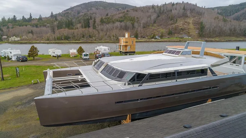 The Image of Modern 2025 Catamaran Bloomfield 86 Motorsailor docked near scenic river and hills. - 0